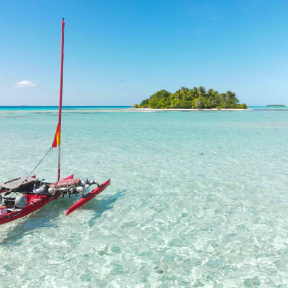 Boat in water with island in background.