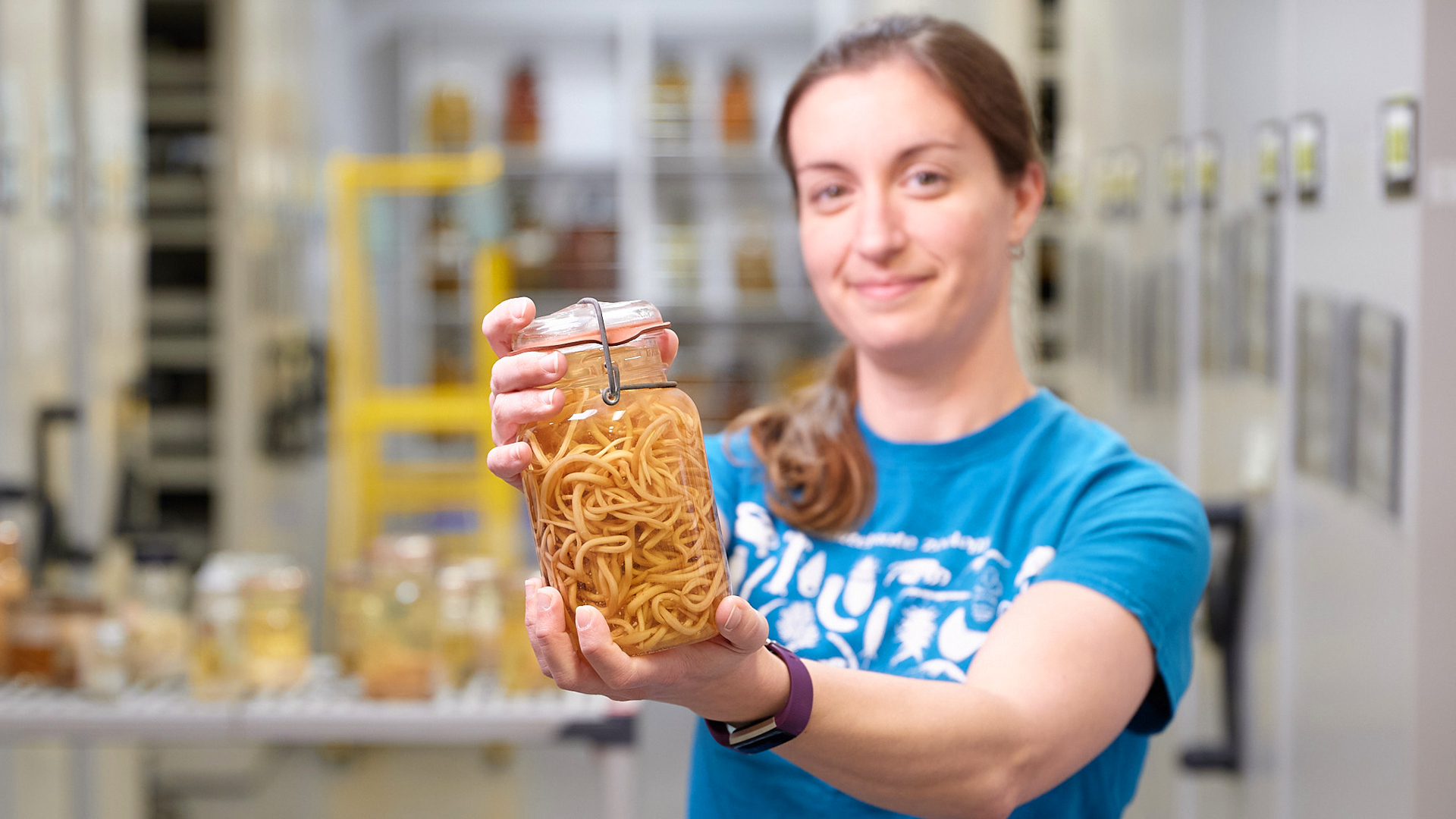 Person holds jar with worms