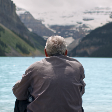 Person looks out on water and mountains