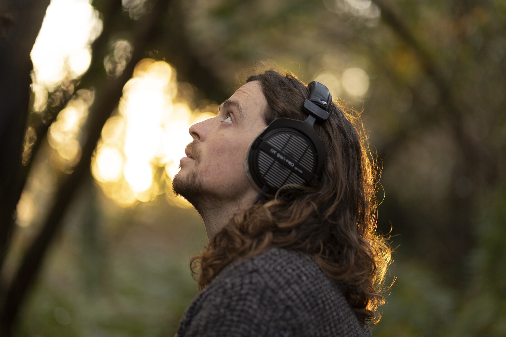 img-6760a4a7cd5a9 Person looking up with headphones on.