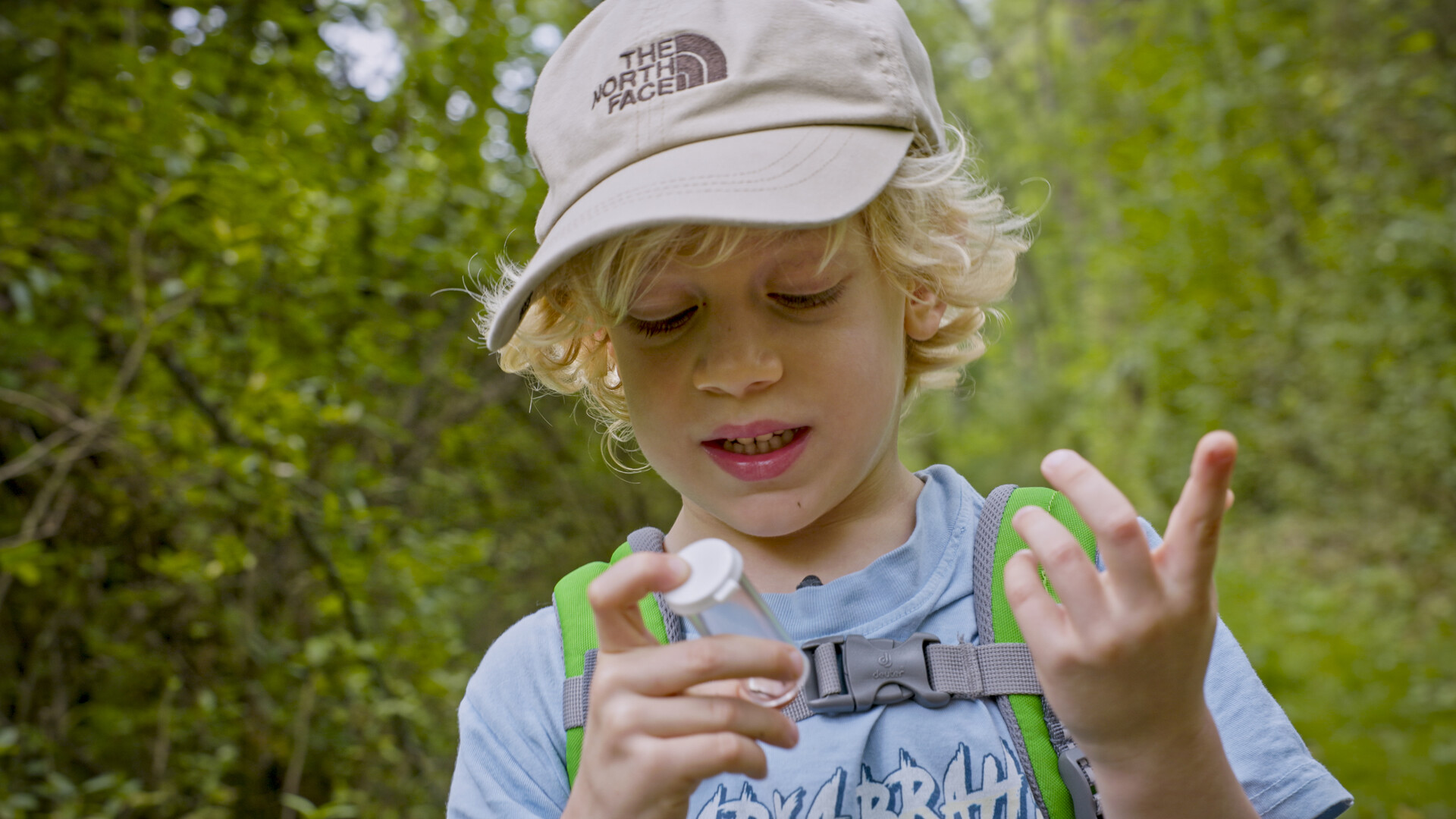Close up of child with vial in hand.
