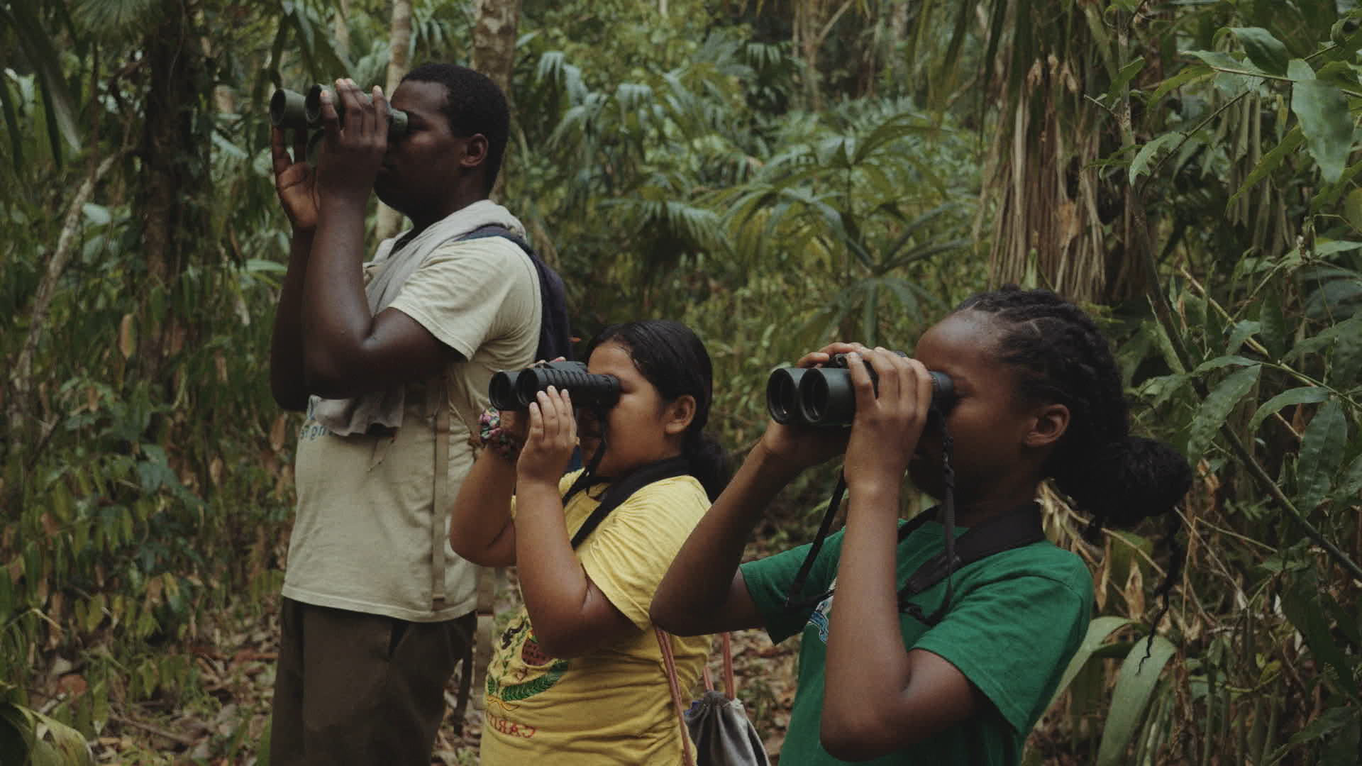 Group of people in forest looking left.