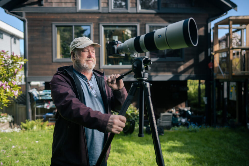 Person outside with camera on tripod.