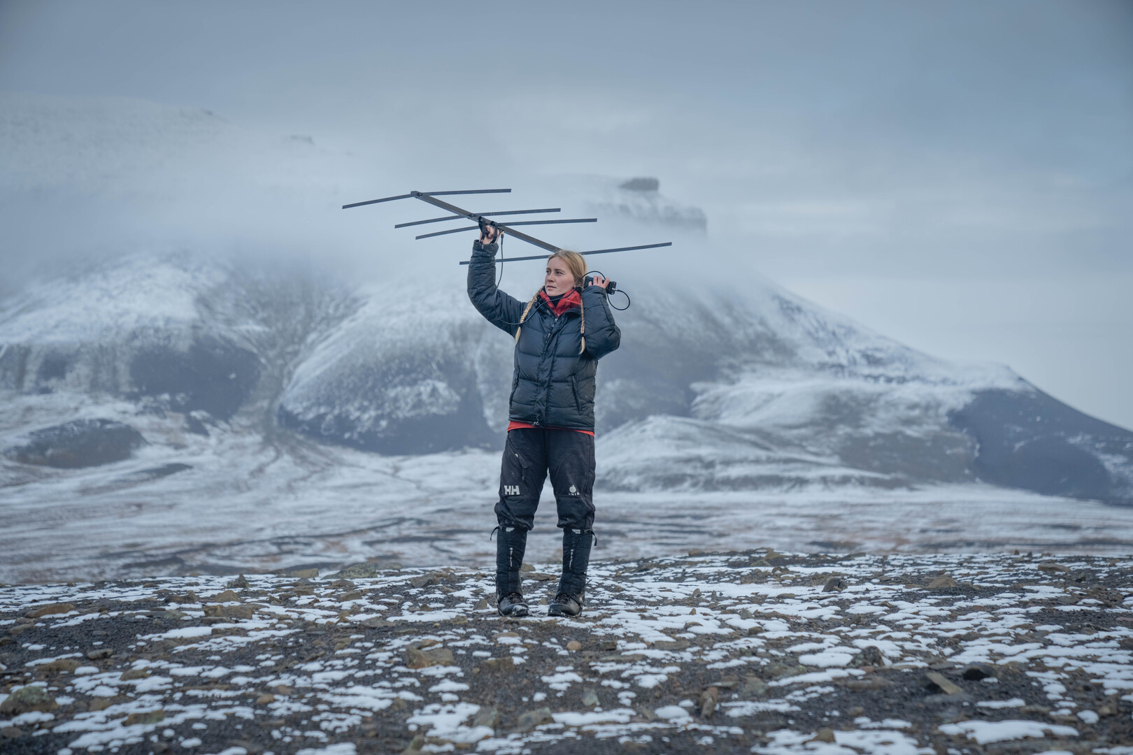 One person stands in snowy landscape with radio transmitter.
