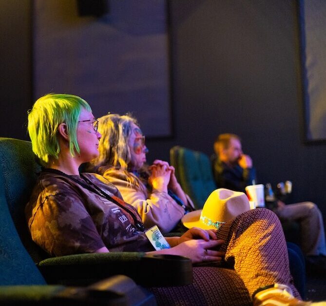 People siting in movie theater.
