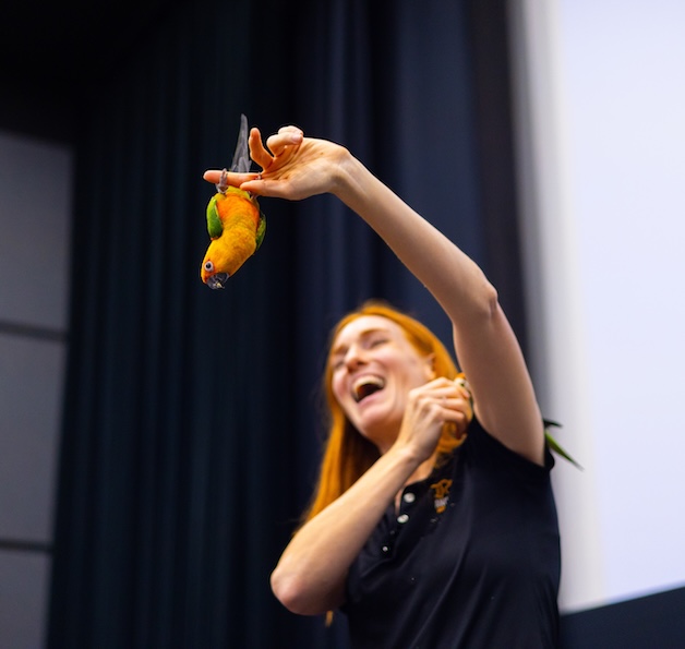 Person holding bird and smiling.
