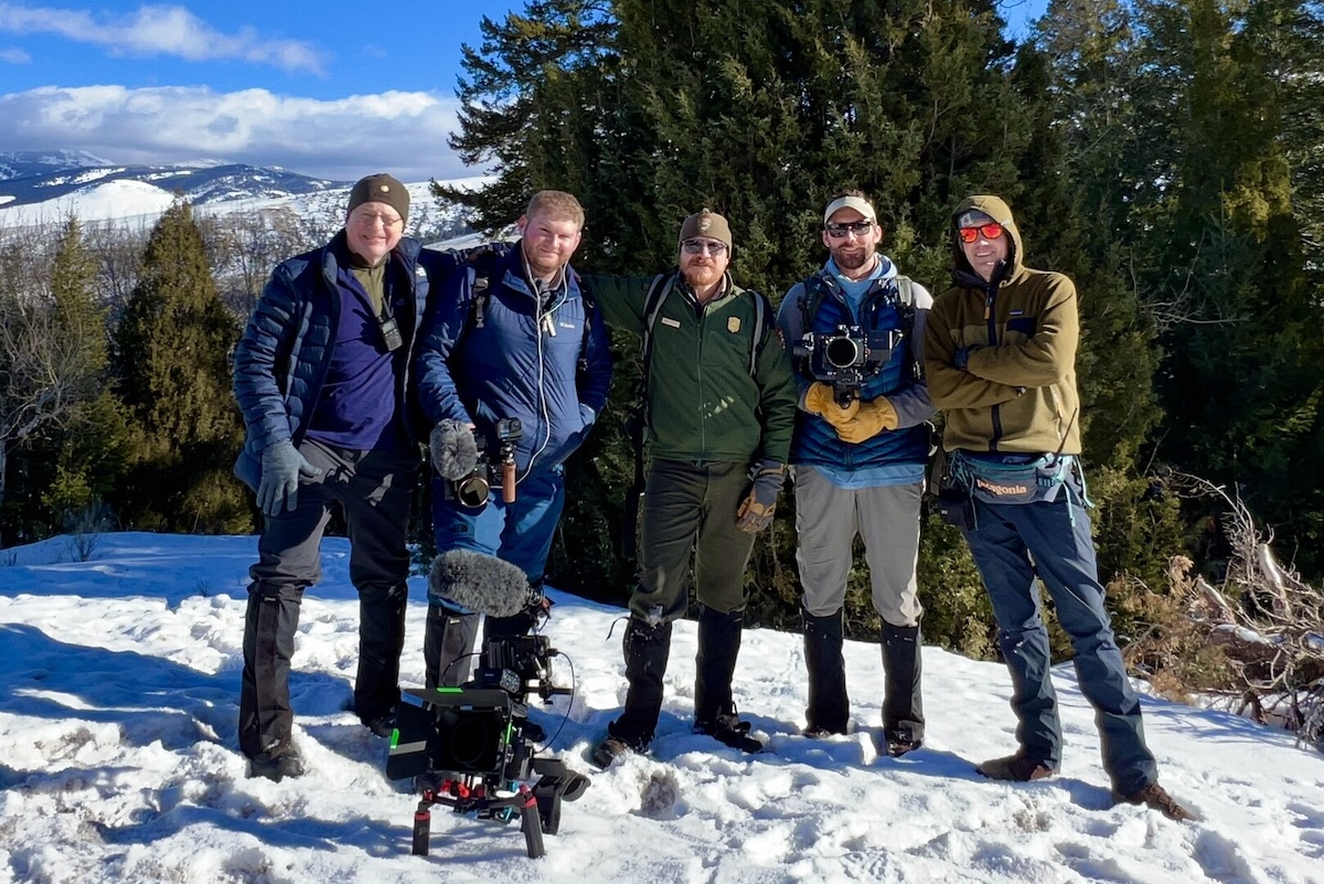 People standing with camera gear in snow.