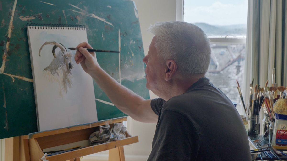 Person paints watercolor of goat.