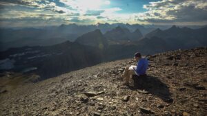 Person sitting in mountains and drawing.