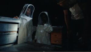 Kids in beekeeping suits.