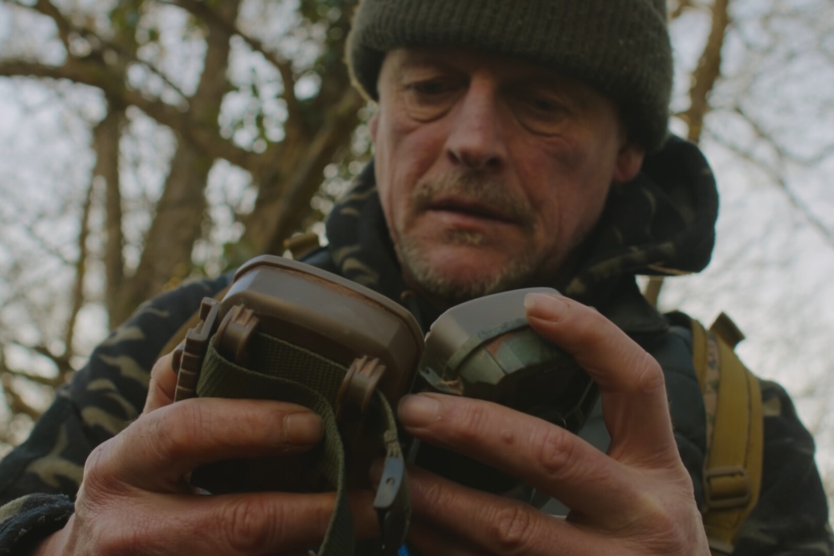 Person holding gear in forest.