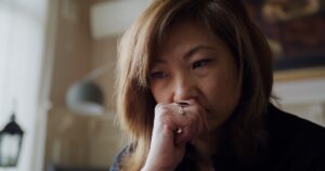 Person holds hand to mouth.