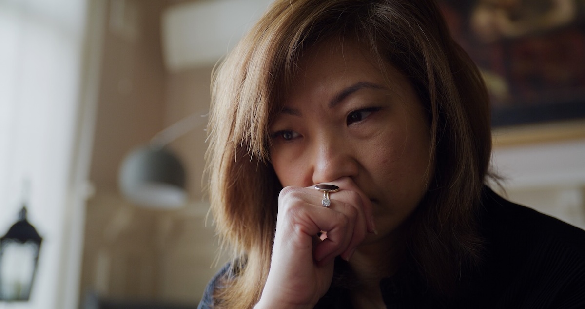 Person holds hand to mouth.