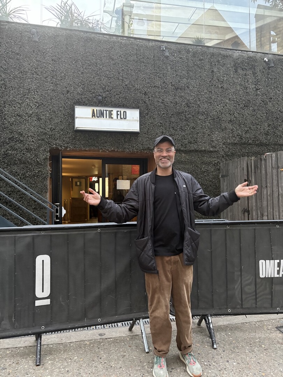 Person standing outside with arms outstretched.