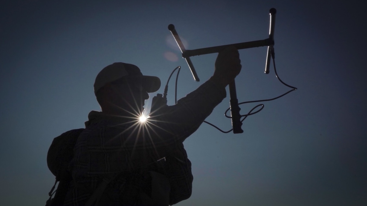 Person holds up antenna.