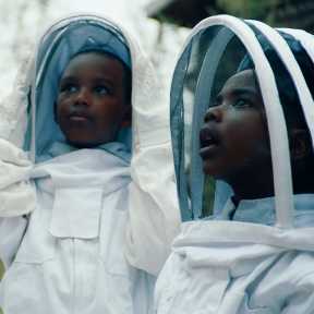 Two kids in beekeeping gear.